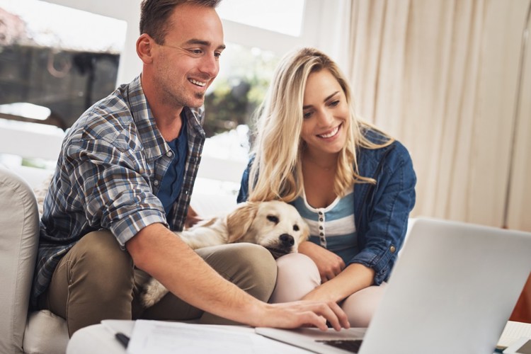 couple and dog on laptop - stock image